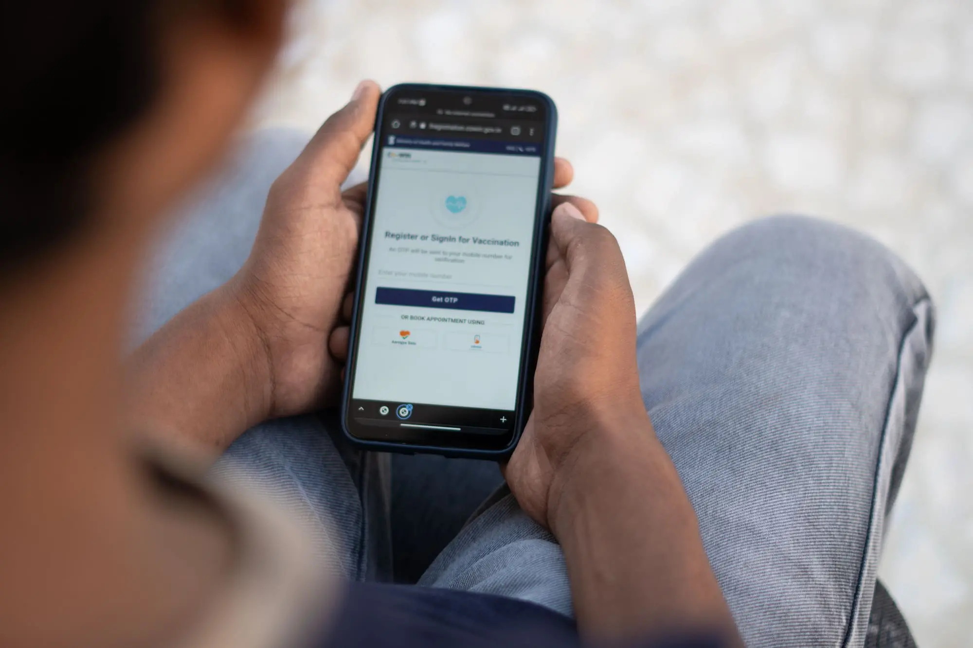 Indian teenager registering himself to get vaccinated using his mobile phone via Cowin platform and booking his appointment for vaccination